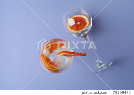Glass of cocktail with grapefruit on violet background Glass of cocktail with grapefruit on violet background 79299473