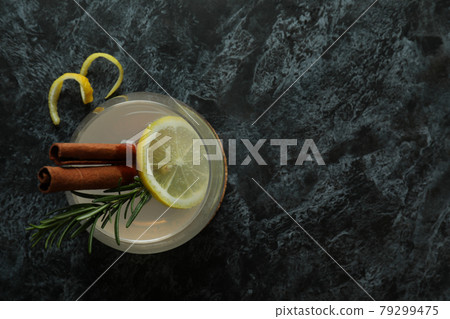 Glass of lemonade with cinnamon and rosemary on black smokey table Glass of lemonade with cinnamon and rosemary on black smokey table 79299475