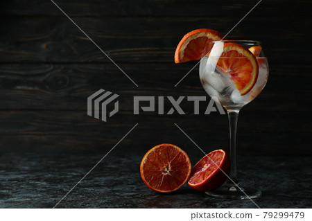 Glass of cocktail with grapefruit on black smokey table Glass of cocktail with grapefruit on black smokey table 79299479