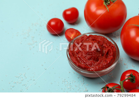 Bowl with tomato paste, tomatoes and salt on blue background 79299484