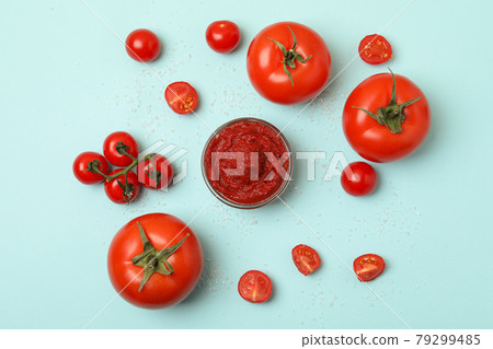 Bowl with tomato paste, tomatoes and salt on blue background Bowl with tomato paste, tomatoes and salt on blue background 79299485