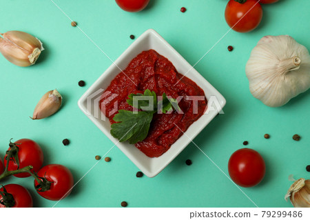 Bowl of tomato paste and ingredients on mint background 79299486
