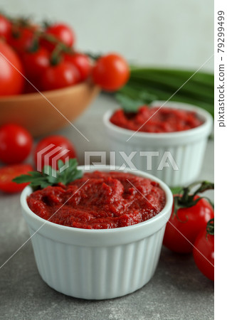 Bowls with tomato paste on gray background with ingredients 79299499