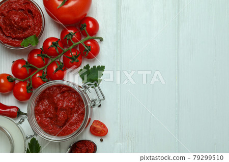 Bowl and jar with tomato paste on white wooden background with ingredients 79299510