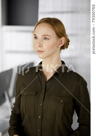 Friendly adult casual dressed business woman standing straight. Business headshot or portrait in office 79300768