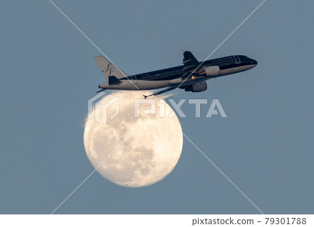 Passenger plane rising over the full moon 79301788