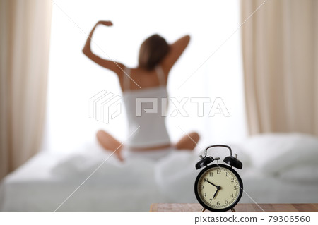 Woman stretching in bed after wake up, back view, entering a day happy and relaxed after good night sleep. Sweet dreams, good morning, new day, weekend, holidays concept Woman stretching in bed after wake up, back view, entering a day happy and relaxed after good night sleep. Sweet dreams, good morning, new day, weekend, holidays concept 79306560
