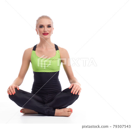 Gorgeous young woman practicing yoga sitting on the floor 79307543