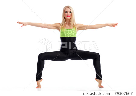 Attractive female gymnast exercising at studio 79307667