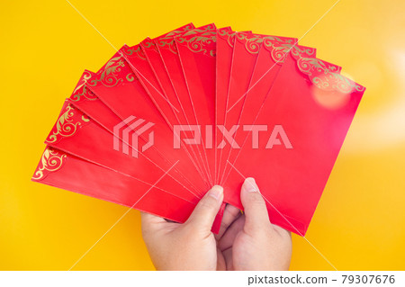 Tet Holiday.Lunar New Year.Chinese New Year . Woman hand holding a pack of red envelope	 79307676