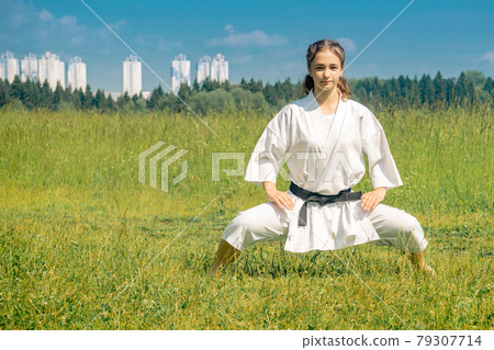 teen girl practicing karate kata outdoors in kiba-dachi stance teen girl practicing karate kata outdoors in kiba-dachi stance 79307714