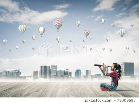 Concept of careless happy childhood with girl looking in spyglas 79309695