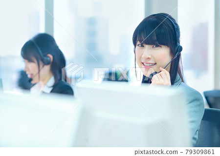 A female operator in a suit who responds to chat in the office A female operator in a suit who responds to chat in the office 79309861