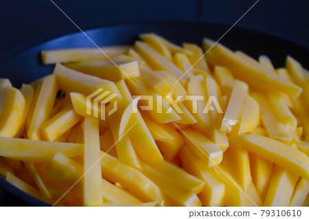 Blurred background. Out of focus. Slices of yellow potatoes in a frying pan. 79310610