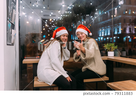 Two young girls using smartphone at the cafe. Two young girls using smartphone at the cafe. 79311883