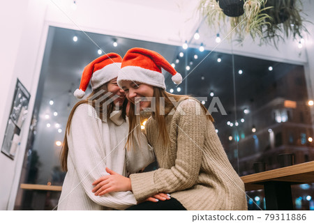 Portrait of happy cute young friends hugging each other at caffe. 79311886