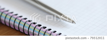 Metal ballpoint pen lying on blank notebook closeup Metal ballpoint pen lying on blank notebook closeup 79312011