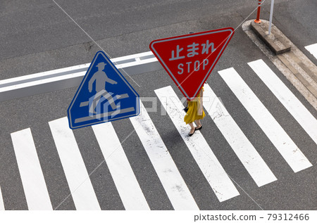 Women crossing the pedestrian crossing and road signs Women crossing the pedestrian crossing and road signs 79312466