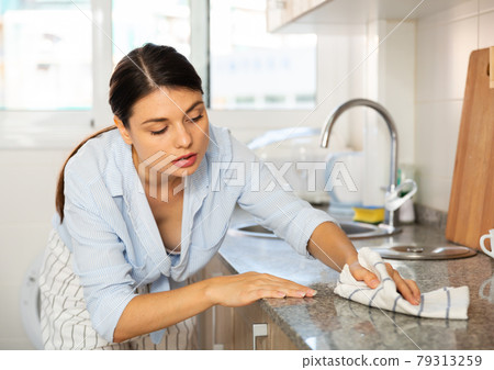 Woman cleaning kitchen after cooking 79313259