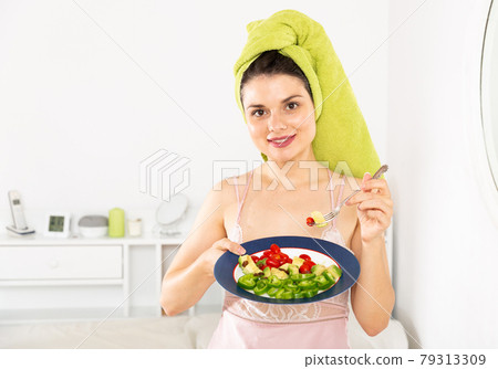 Pretty woman with a towel on his head eating vegetable salad 79313309