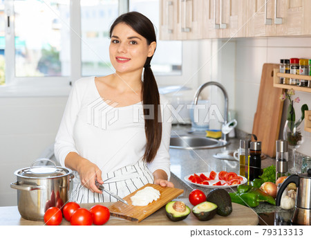 Housewife prepares tomato and avocado salad in the kitchen Housewife prepares tomato and avocado salad in the kitchen 79313313