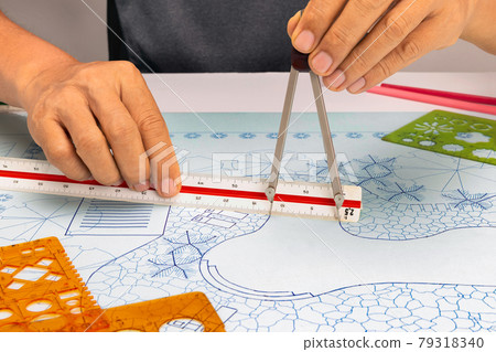 landscape architect student use dividers and scale ruler on blueprint  in class. 79318340