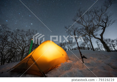 Snowy mountains, starry sky and tent 79319219
