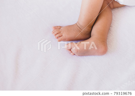 Close up of little feet newborn baby lying on a comfortable bed at home 79319676