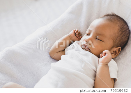 Adorable little asian newborn baby sleeping on a comfortable bed 79319682