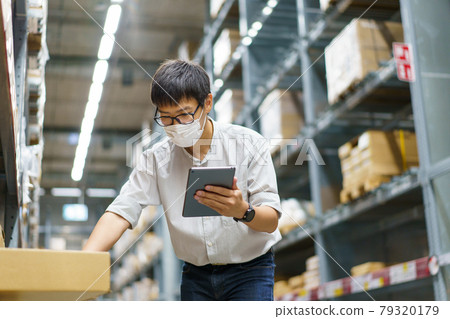 Portrait Asian men, staff, product counting Warehouse Control Manager Standing, counting and inspecting products in the warehouse 79320179