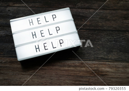 Help word text in light box on wooden background Help word text in light box on wooden background 79320355