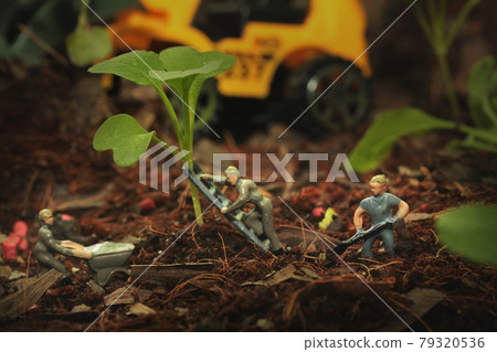 3 Mini people working in digging, climbing stairs, pushing a truck to work under the young trees of vegetables in agricultural plots. 79320536