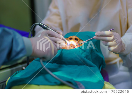 The doctor cleaning the teeth patient with ultrasonic tool The doctor cleaning the teeth patient with ultrasonic tool 79322646