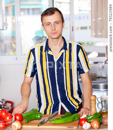 Male cooking from raw vegetables in home kitchen Male cooking from raw vegetables in home kitchen 79322984