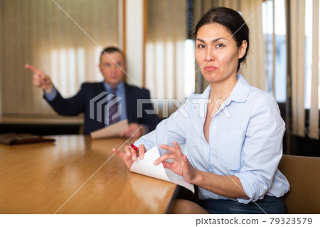 Frustrated female entrepreneur sitting in office with angry partner 79323579