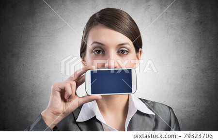 Woman covering her mouth with smartphone Woman covering her mouth with smartphone 79323706
