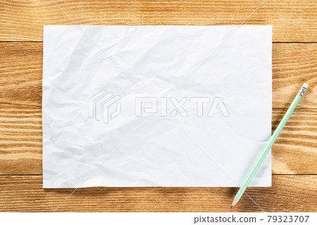 Sheet of paper lying on wooden table 79323707