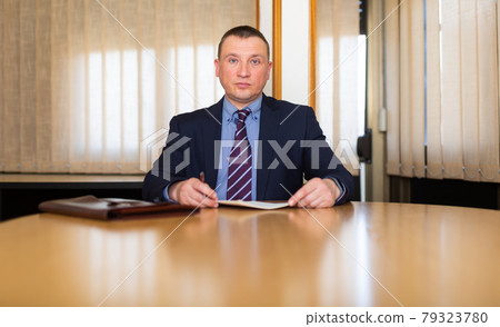 Middle aged man signing apply for job at meeting room 79323780