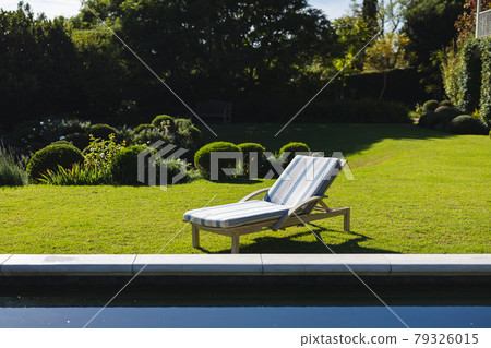 General view of tranquil swimming pool and deckchair with stunning mountains countryside 79326015