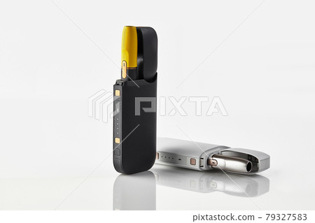 New generation black and yellow, white electronic cigarettes in open batteries isolated on white. Heating tobacco system. Advertising, close up New generation black and yellow, white electronic cigarettes in open batteries isolated on white. Heating tobacco system. Advertising, close up 79327583