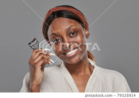 Beautiful African American Woman Curling Eyelashes 79328914