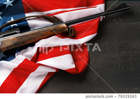 Automatic rifle on USA flag on wooden background 79329163