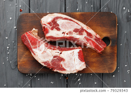 Uncooked raw beef brisket on wooden board Uncooked raw beef brisket on wooden board 79329343