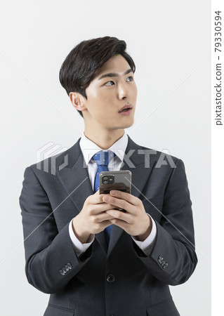 Asian man businessman holding smartphone, looking at side Asian man businessman holding smartphone, looking at side 79330594