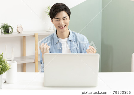 happy young Asian handsome man checking test, job result with laptop happy young Asian handsome man checking test, job result with laptop 79330596