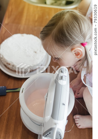 Children in the kitchen cook with their parents. Making homemade cake, pastries or cookies for the whole family. Happy childhood concept. Little twin sisters in kitchen aprons and chef hats Children in the kitchen cook with their parents. Making homemade cake, pastries or cookies for the whole family. Happy childhood concept. Little twin sisters in kitchen aprons and chef hats 79330619