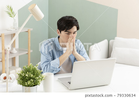 handsome young Asian job seeker checking result through laptop handsome young Asian job seeker checking result through laptop 79330634