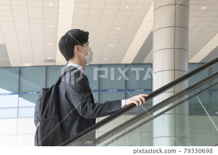 Asian man employee with mask riding elevator Asian man employee with mask riding elevator 79330698