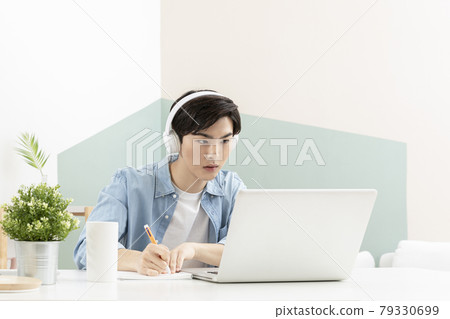 Asian handsome young man with headset, studying using laptop Asian handsome young man with headset, studying using laptop 79330699