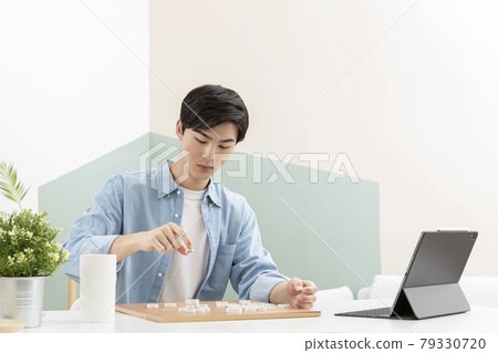 Asian young man learning chess through online class using tablet device Asian young man learning chess through online class using tablet device 79330720